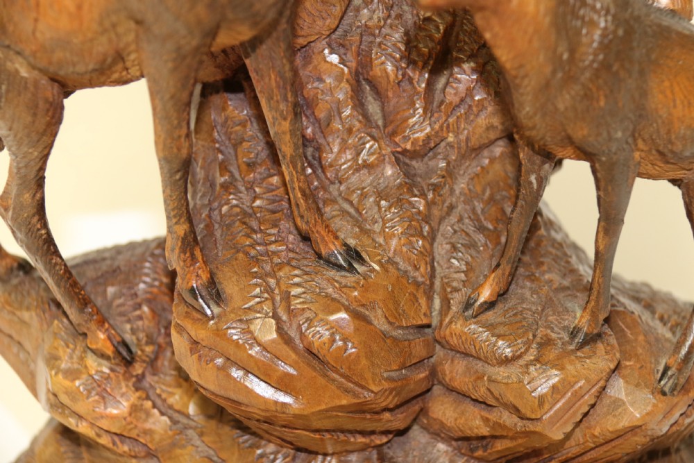 A pair of hand-carved wooden sculptures depicting ibex and chamois with offspring on carved rocky bases. View XXII