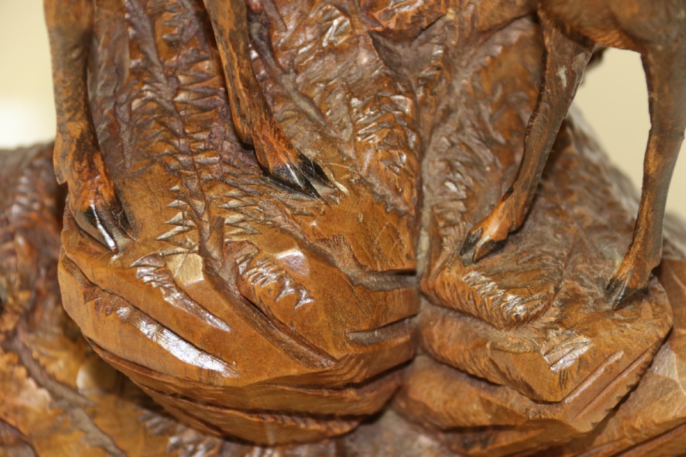 A pair of hand-carved wooden sculptures depicting ibex and chamois with offspring on carved rocky bases. View XXV