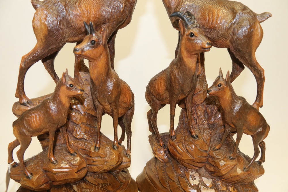 A pair of hand-carved wooden sculptures depicting ibex and chamois with offspring on carved rocky bases. View XXVIII