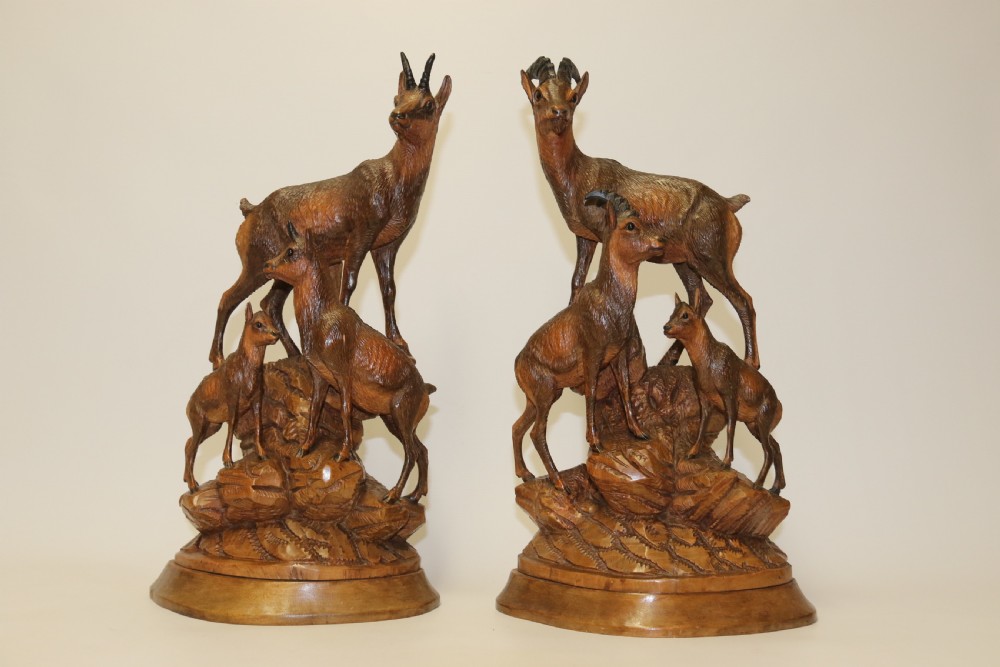 A pair of hand-carved wooden sculptures depicting ibex and chamois with offspring on carved rocky bases. View XXIX