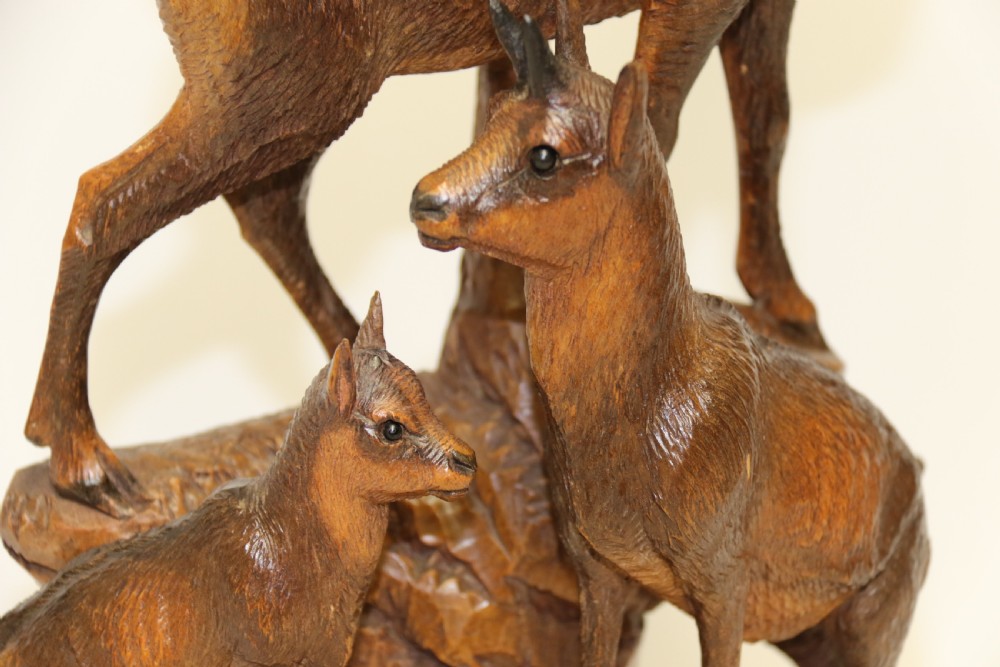 A pair of hand-carved wooden sculptures depicting ibex and chamois with offspring on carved rocky bases. View XXXI