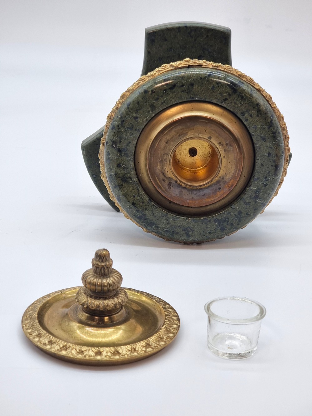 A French Empire style green marble inkstand featuring a central urn-shaped vessel with gilt bronze floral borders and a decorative finial lid, supported by three lion paw feet on a curved marble base. View XII