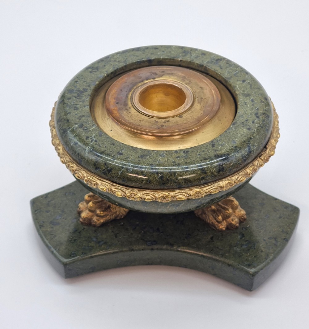 A French Empire style green marble inkstand featuring a central urn-shaped vessel with gilt bronze floral borders and a decorative finial lid, supported by three lion paw feet on a curved marble base. View XIV