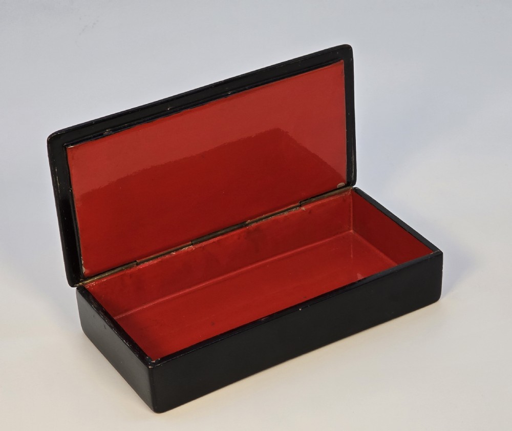 A rectangular black lacquered papier-mache box featuring a detailed hand-painted scene from Russian folklore framed by a delicate gold filigree border. View IV