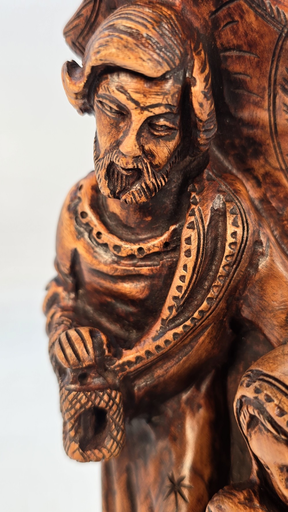 A carved olive wood sculpture depicting Saint Joseph, Mary, and the infant Jesus on an incised wooden base. View XI