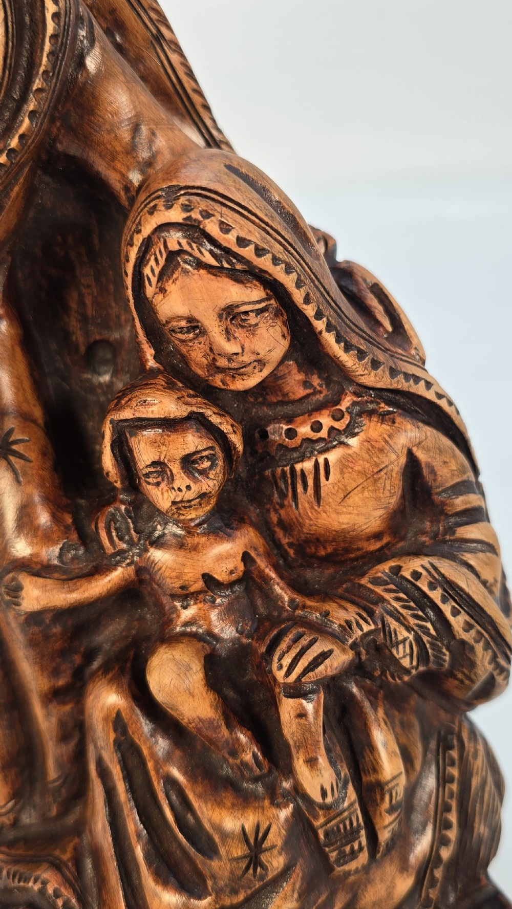 A carved olive wood sculpture depicting Saint Joseph, Mary, and the infant Jesus on an incised wooden base. View XII