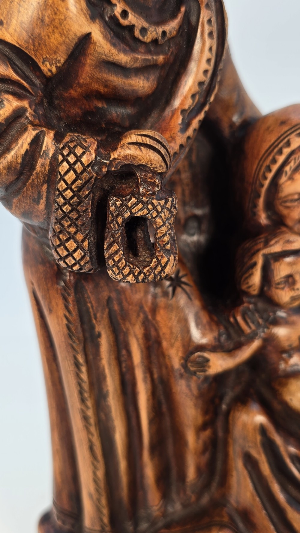 A carved olive wood sculpture depicting Saint Joseph, Mary, and the infant Jesus on an incised wooden base. View XIII