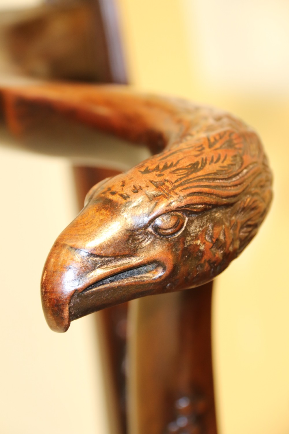 A late 19th-century Chippendale style mahogany armchair featuring carved eagle head terminals, a pierced back splat, brown leather seat, and cabriole legs with claw and ball feet. View V