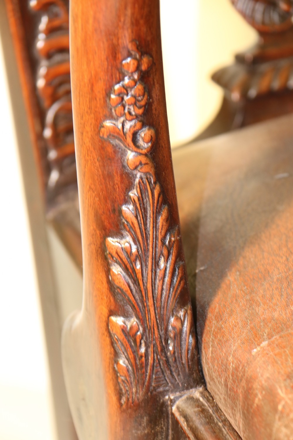 A late 19th-century Chippendale style mahogany armchair featuring carved eagle head terminals, a pierced back splat, brown leather seat, and cabriole legs with claw and ball feet. View VI