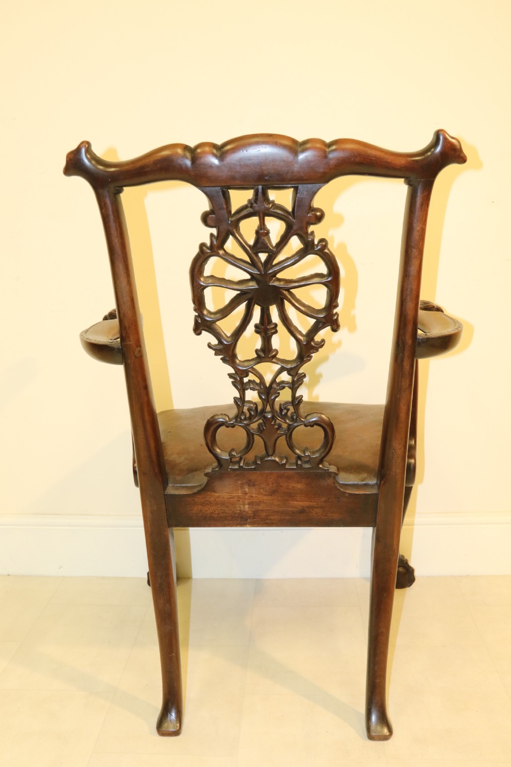 A late 19th-century Chippendale style mahogany armchair featuring carved eagle head terminals, a pierced back splat, brown leather seat, and cabriole legs with claw and ball feet. View XVI