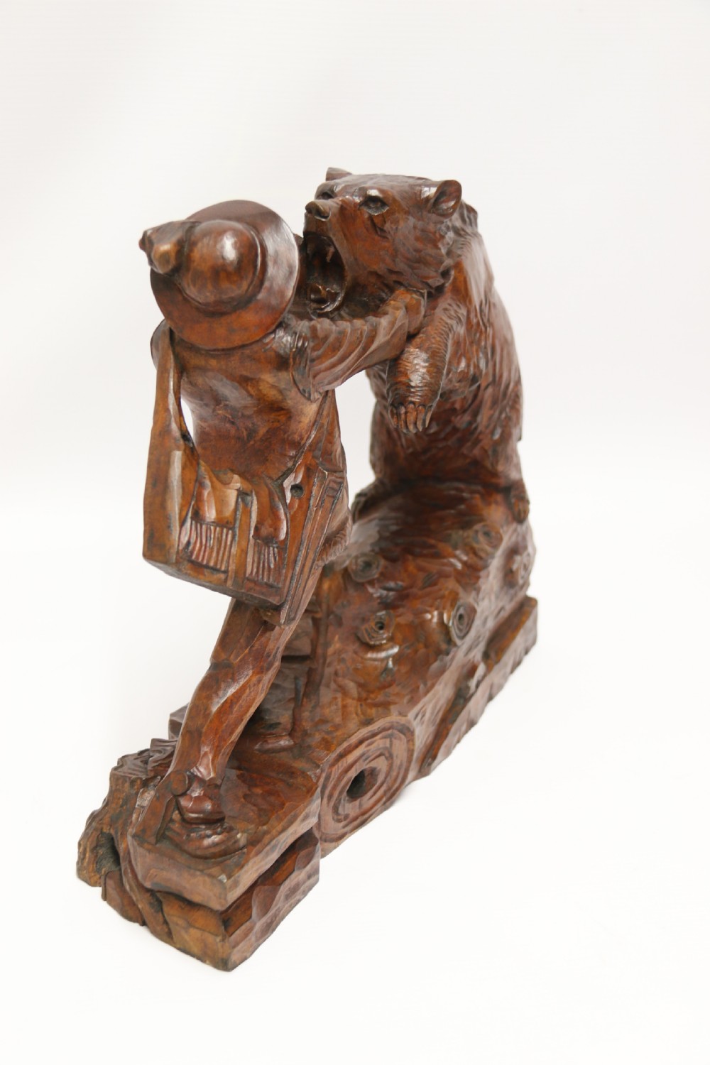 A late 19th-century carved wooden figure group depicting a huntsman battling a rearing bear on a log-form base. View III