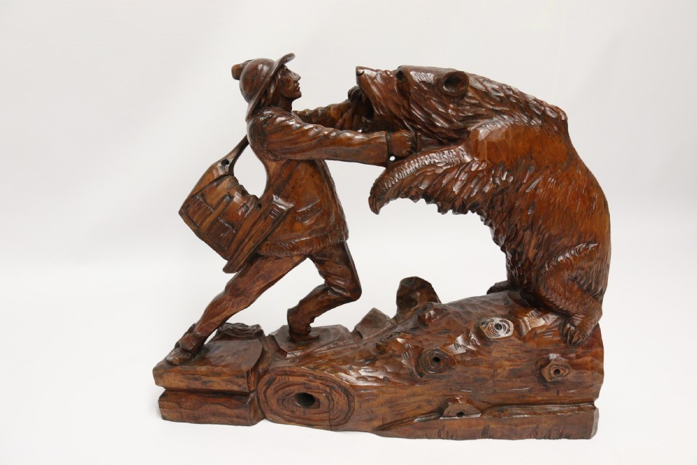 A late 19th-century carved wooden figure group depicting a huntsman battling a rearing bear on a log-form base. View V