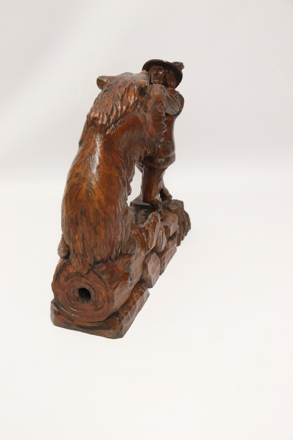 A late 19th-century carved wooden figure group depicting a huntsman battling a rearing bear on a log-form base. View VI