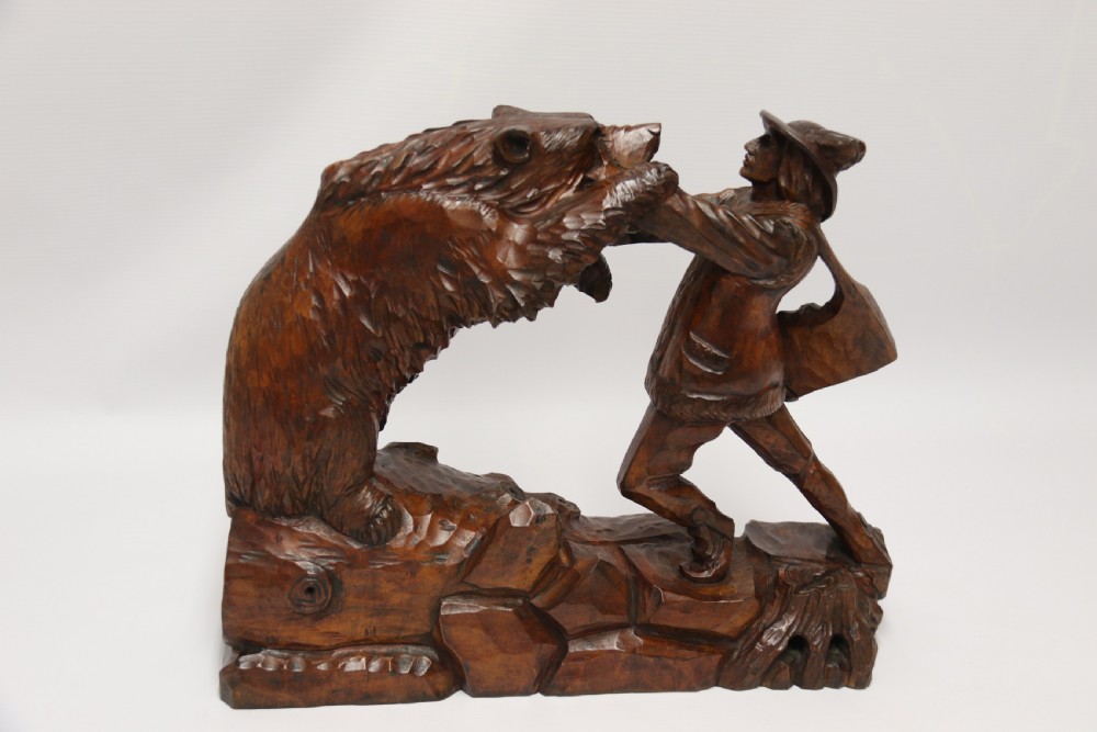 A late 19th-century carved wooden figure group depicting a huntsman battling a rearing bear on a log-form base. View VII