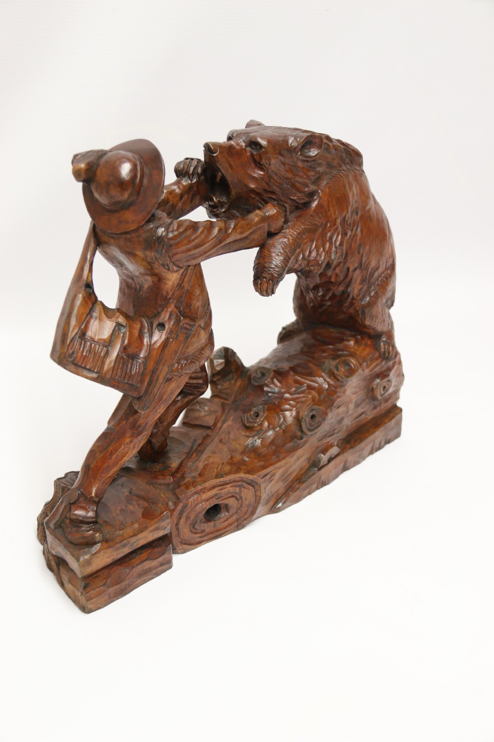 A late 19th-century carved wooden figure group depicting a huntsman battling a rearing bear on a log-form base. View IX