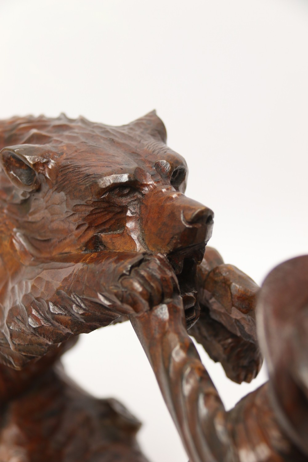 A late 19th-century carved wooden figure group depicting a huntsman battling a rearing bear on a log-form base. View XIV
