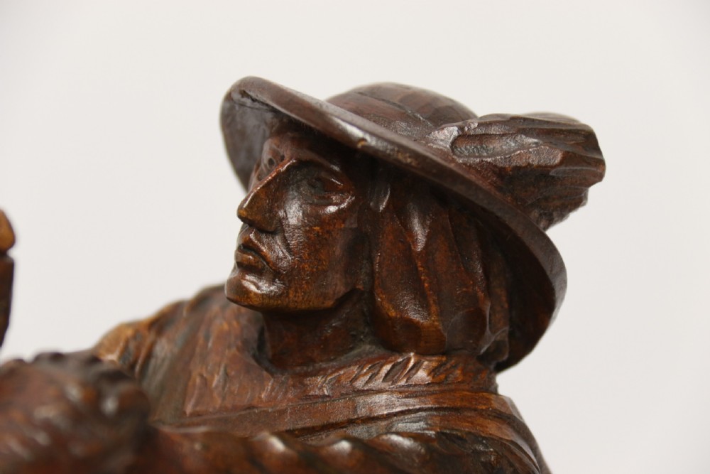 A late 19th-century carved wooden figure group depicting a huntsman battling a rearing bear on a log-form base. View XV
