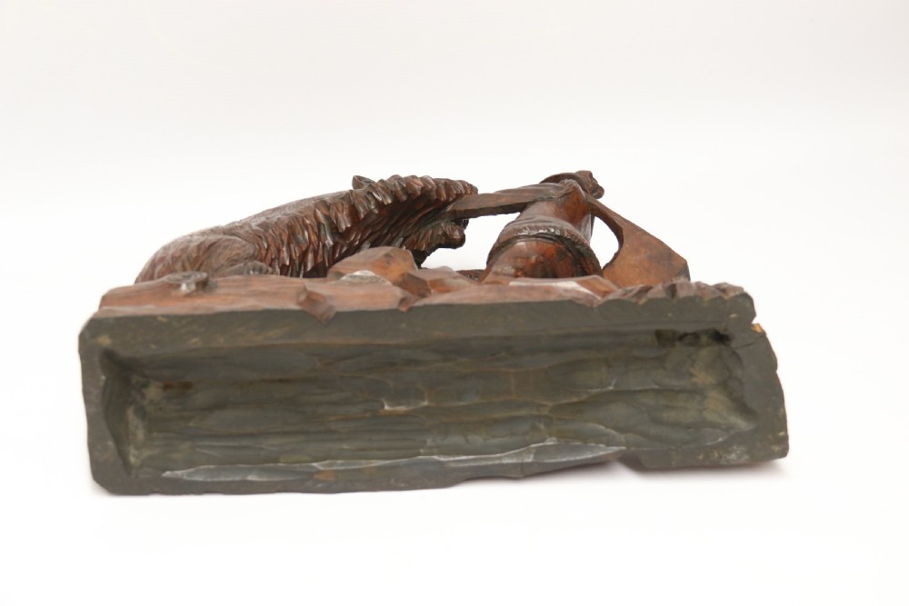 A late 19th-century carved wooden figure group depicting a huntsman battling a rearing bear on a log-form base. View XVI