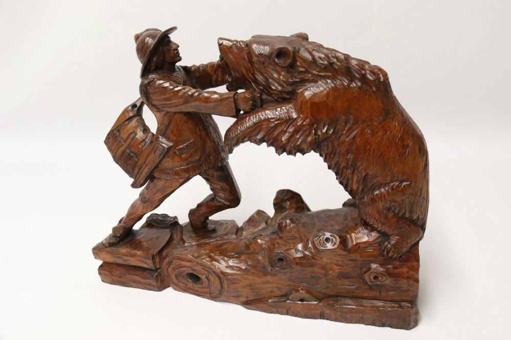 A late 19th-century carved wooden figure group depicting a huntsman battling a rearing bear on a log-form base. View XXI