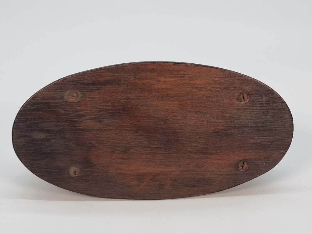 An oval wooden box constructed with radially segmented burr walnut veneer, a dark central oval inlay, and a moulded ebonised base. View IX