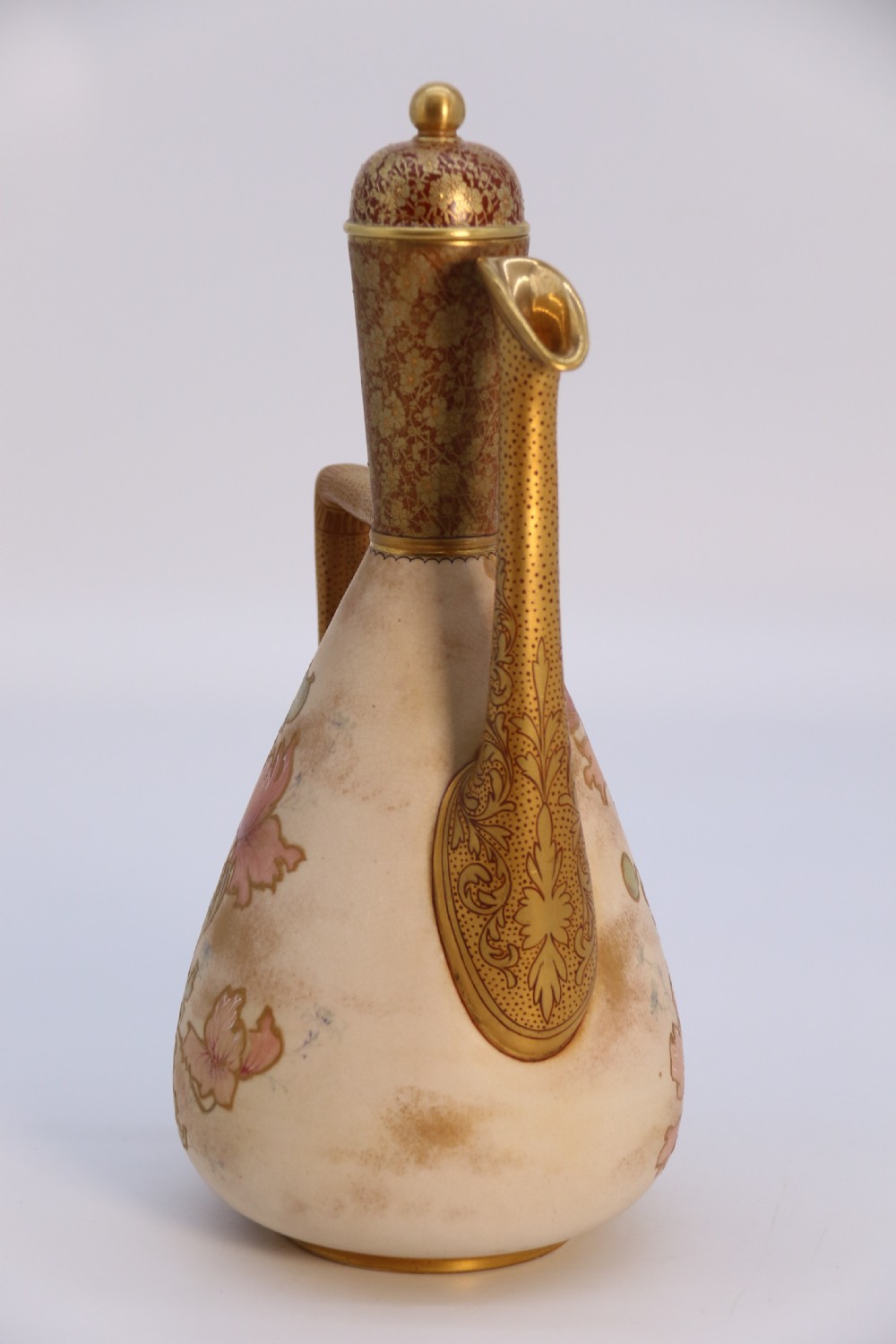 A late 19th-century Doulton Burslem ceramic ewer featuring hand-painted pink floral motifs, an elongated gilt spout, stippled gold handle, and matching stopper. View VII