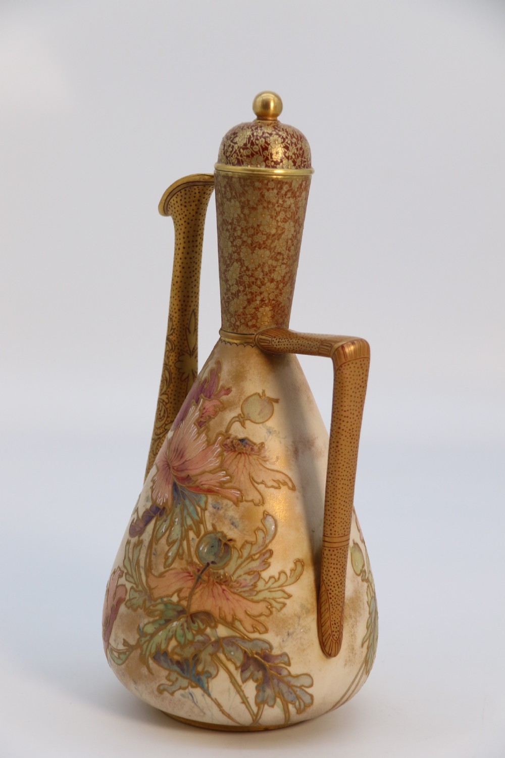 A late 19th-century Doulton Burslem ceramic ewer featuring hand-painted pink floral motifs, an elongated gilt spout, stippled gold handle, and matching stopper. View XI