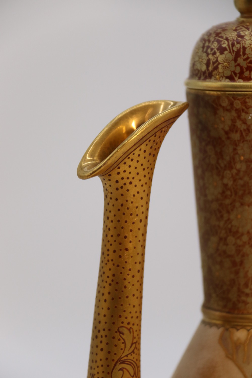 A late 19th-century Doulton Burslem ceramic ewer featuring hand-painted pink floral motifs, an elongated gilt spout, stippled gold handle, and matching stopper. View XIV