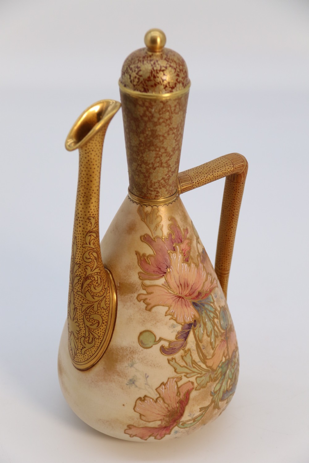 A late 19th-century Doulton Burslem ceramic ewer featuring hand-painted pink floral motifs, an elongated gilt spout, stippled gold handle, and matching stopper. View XXII