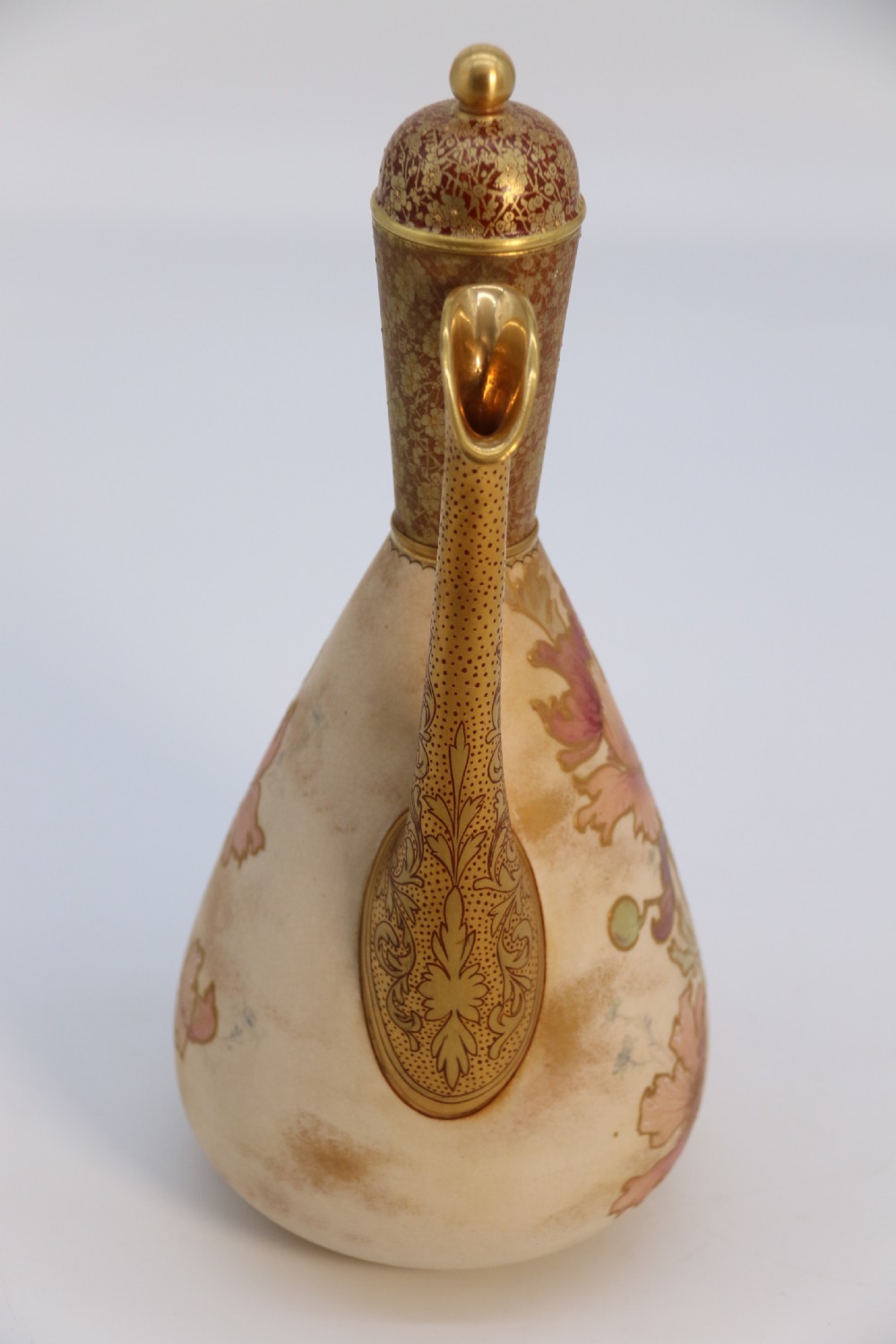 A late 19th-century Doulton Burslem ceramic ewer featuring hand-painted pink floral motifs, an elongated gilt spout, stippled gold handle, and matching stopper. View XXIII