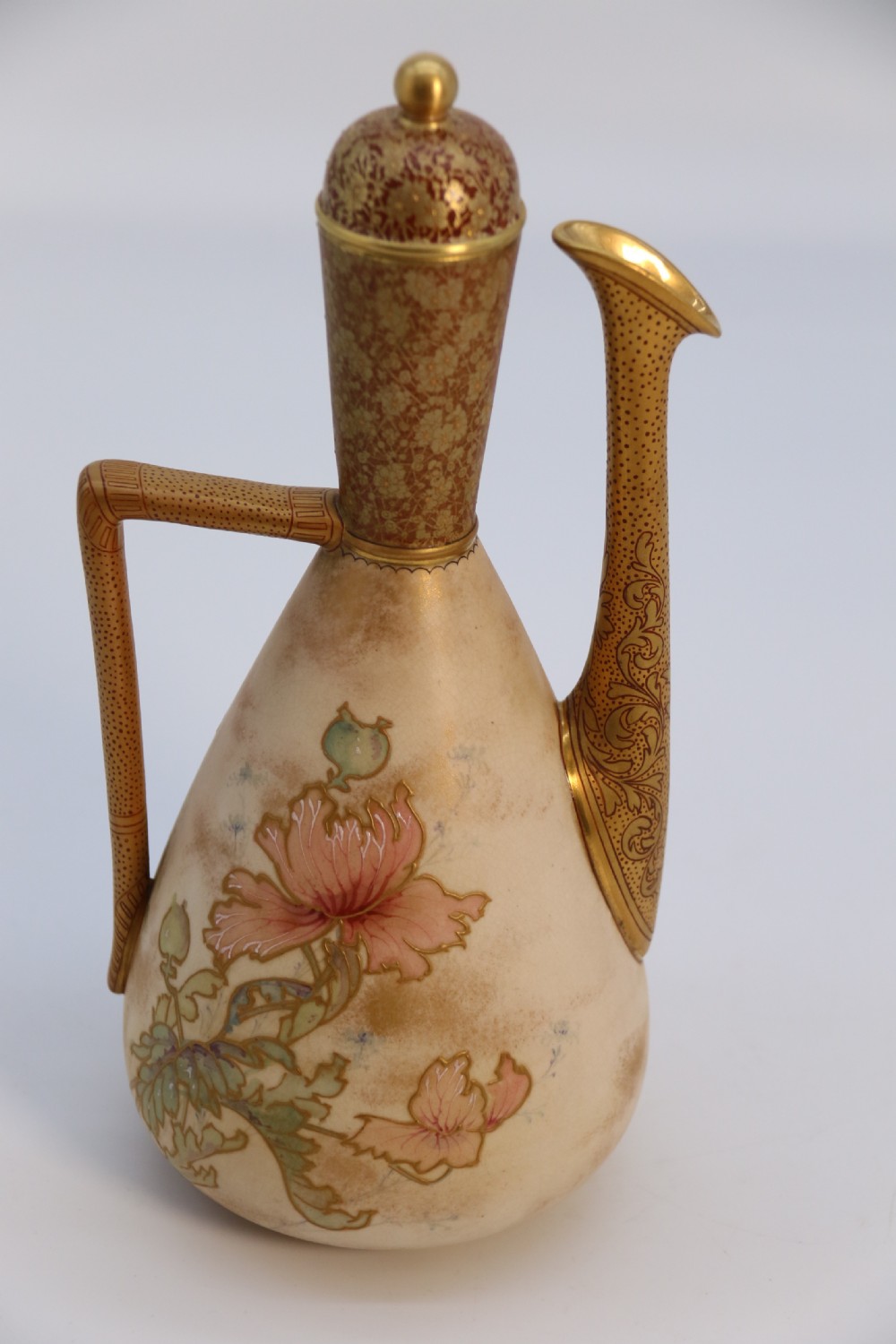 A late 19th-century Doulton Burslem ceramic ewer featuring hand-painted pink floral motifs, an elongated gilt spout, stippled gold handle, and matching stopper. View XXIV