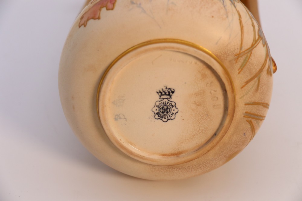 A late 19th-century Doulton Burslem ceramic ewer featuring hand-painted pink floral motifs, an elongated gilt spout, stippled gold handle, and matching stopper. View XXVI