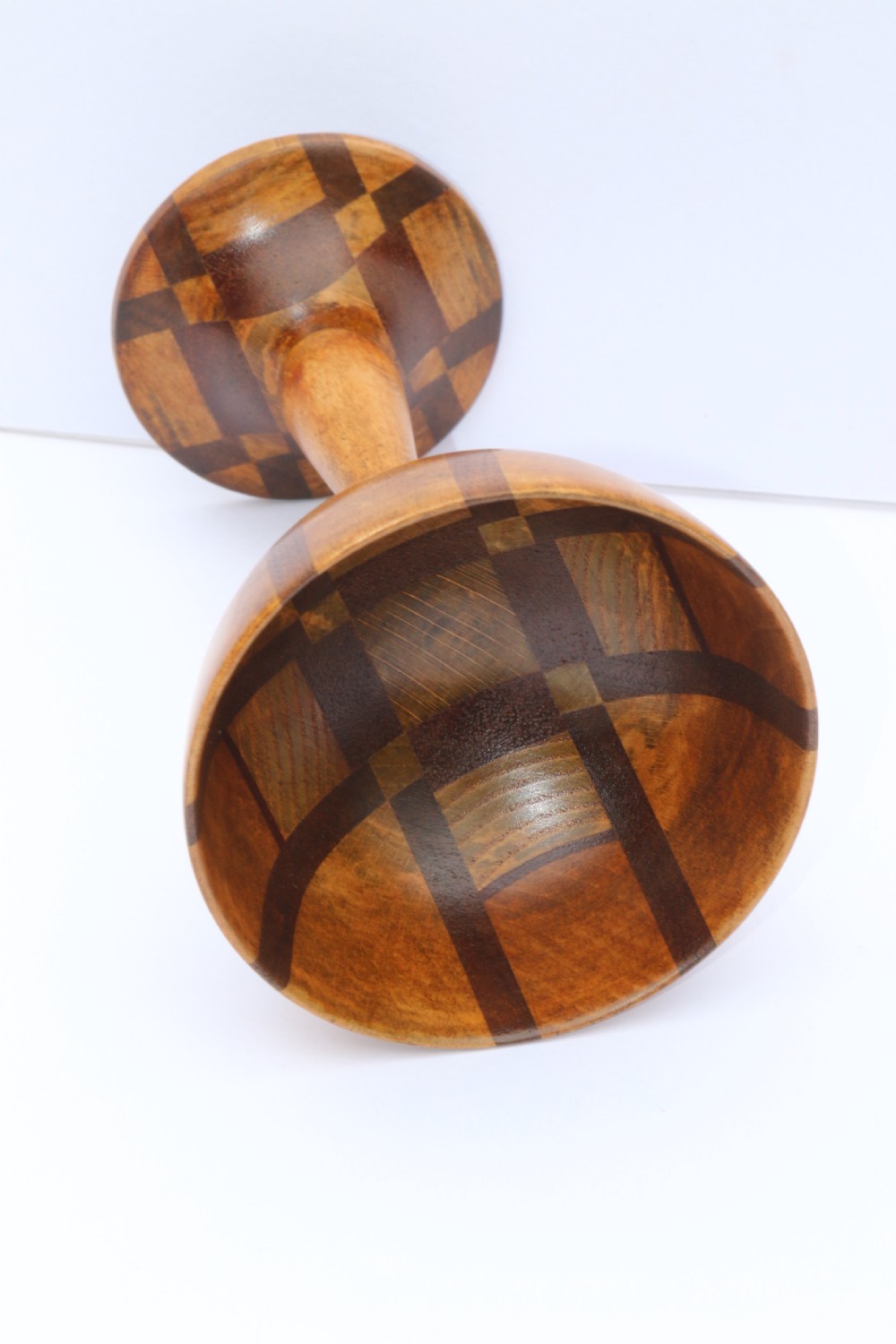 A turned wooden goblet crafted from contrasting specimen woods with a flared rim, a slender stem, and a round patterned base. View V