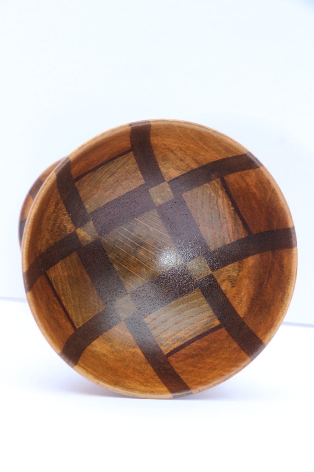 A turned wooden goblet crafted from contrasting specimen woods with a flared rim, a slender stem, and a round patterned base. View VI