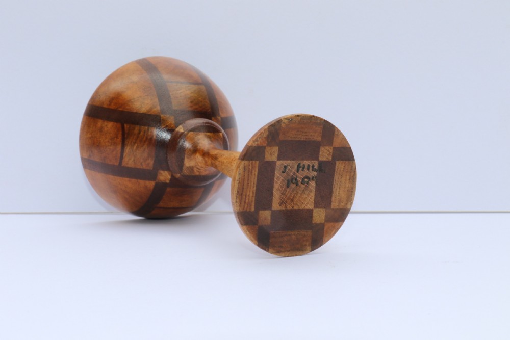 A turned wooden goblet crafted from contrasting specimen woods with a flared rim, a slender stem, and a round patterned base. View VIII