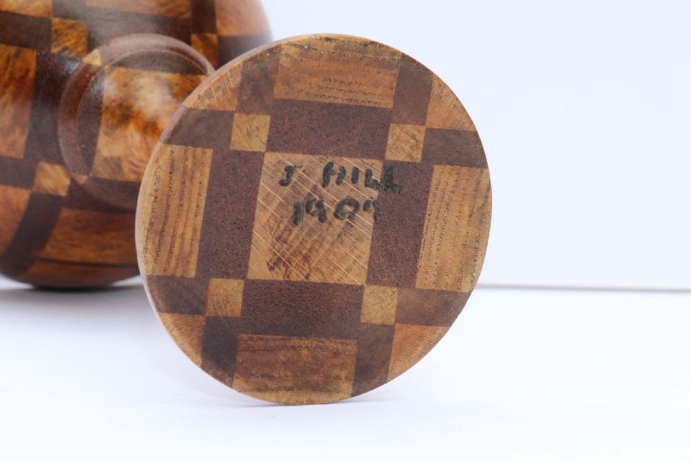 A turned wooden goblet crafted from contrasting specimen woods with a flared rim, a slender stem, and a round patterned base. View IX