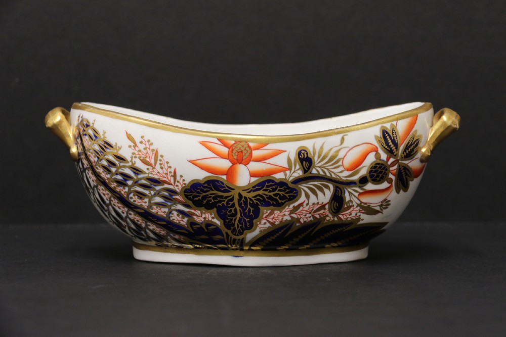 An early nineteenth-century boat-shaped white porcelain shallow dish with gilded side handles, decorated in hand-painted Imari floral motifs in cobalt blue, iron red, and gold. View II