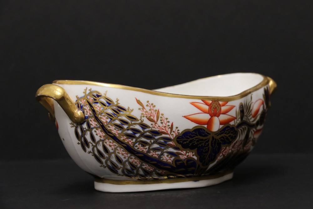 An early nineteenth-century boat-shaped white porcelain shallow dish with gilded side handles, decorated in hand-painted Imari floral motifs in cobalt blue, iron red, and gold. View III