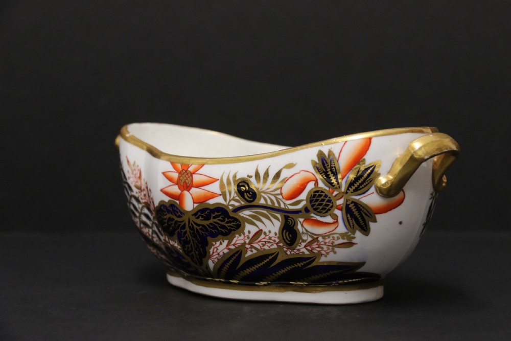 An early nineteenth-century boat-shaped white porcelain shallow dish with gilded side handles, decorated in hand-painted Imari floral motifs in cobalt blue, iron red, and gold. View VI