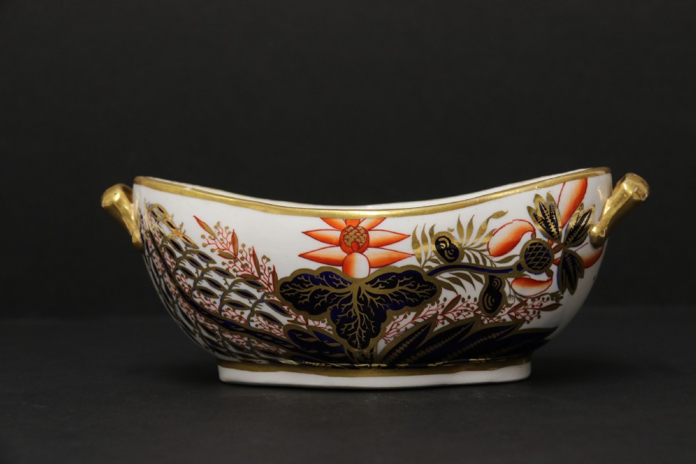 An early nineteenth-century boat-shaped white porcelain shallow dish with gilded side handles, decorated in hand-painted Imari floral motifs in cobalt blue, iron red, and gold. View VIII
