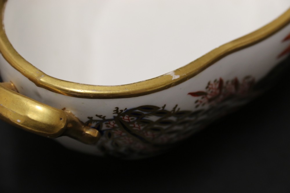 An early nineteenth-century boat-shaped white porcelain shallow dish with gilded side handles, decorated in hand-painted Imari floral motifs in cobalt blue, iron red, and gold. View IX