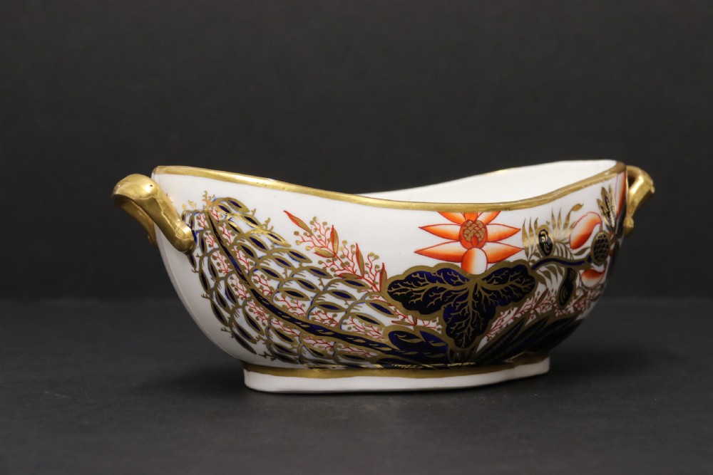 An early nineteenth-century boat-shaped white porcelain shallow dish with gilded side handles, decorated in hand-painted Imari floral motifs in cobalt blue, iron red, and gold. View XI
