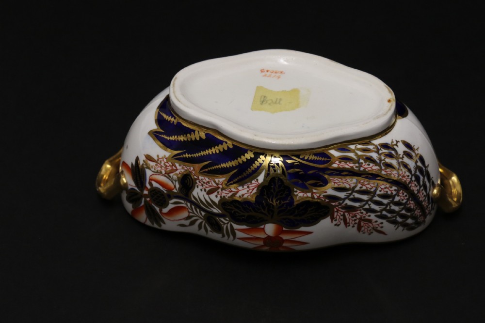 An early nineteenth-century boat-shaped white porcelain shallow dish with gilded side handles, decorated in hand-painted Imari floral motifs in cobalt blue, iron red, and gold. View XII