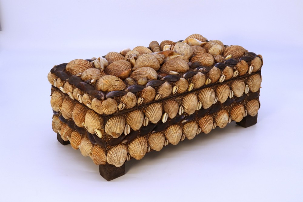 A rectangular folk art box raised on four small feet, fully encrusted with an intricate mosaic of natural sea shells including cockles, cowries, and mussels. View IX
