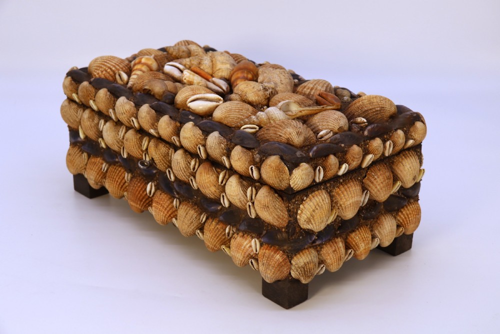A rectangular folk art box raised on four small feet, fully encrusted with an intricate mosaic of natural sea shells including cockles, cowries, and mussels. View XI