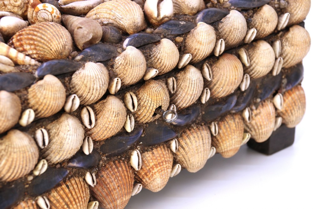 A rectangular folk art box raised on four small feet, fully encrusted with an intricate mosaic of natural sea shells including cockles, cowries, and mussels. View XXI