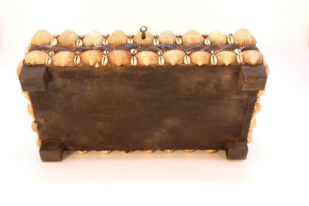 A rectangular folk art box raised on four small feet, fully encrusted with an intricate mosaic of natural sea shells including cockles, cowries, and mussels. View XXIV