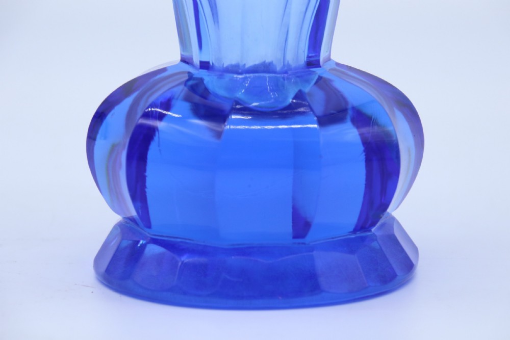 A flared Art Deco sapphire blue cut glass vase featuring geometric carved details on a faceted bulbous pedestal base. View VII