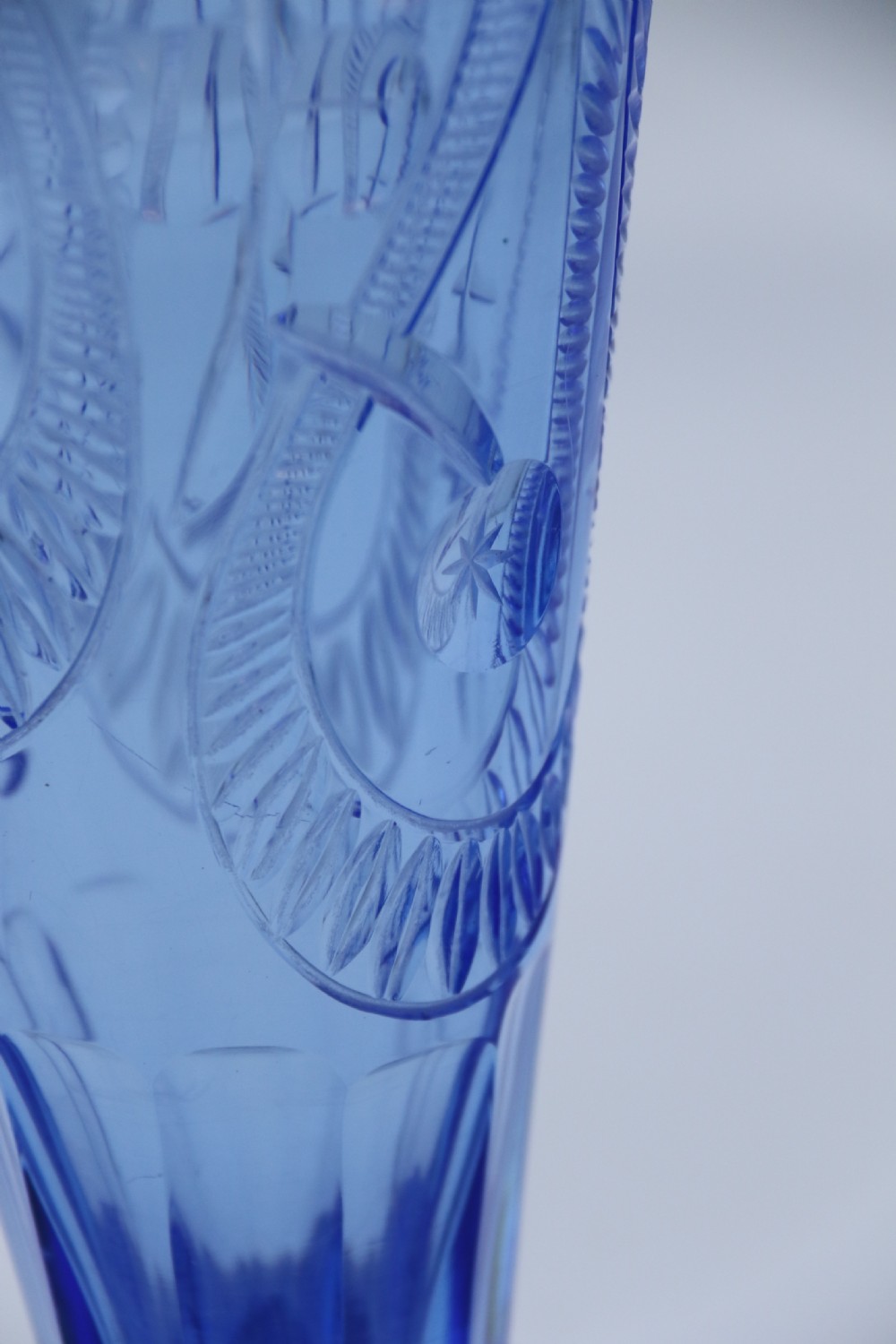 A flared Art Deco sapphire blue cut glass vase featuring geometric carved details on a faceted bulbous pedestal base. View VIII