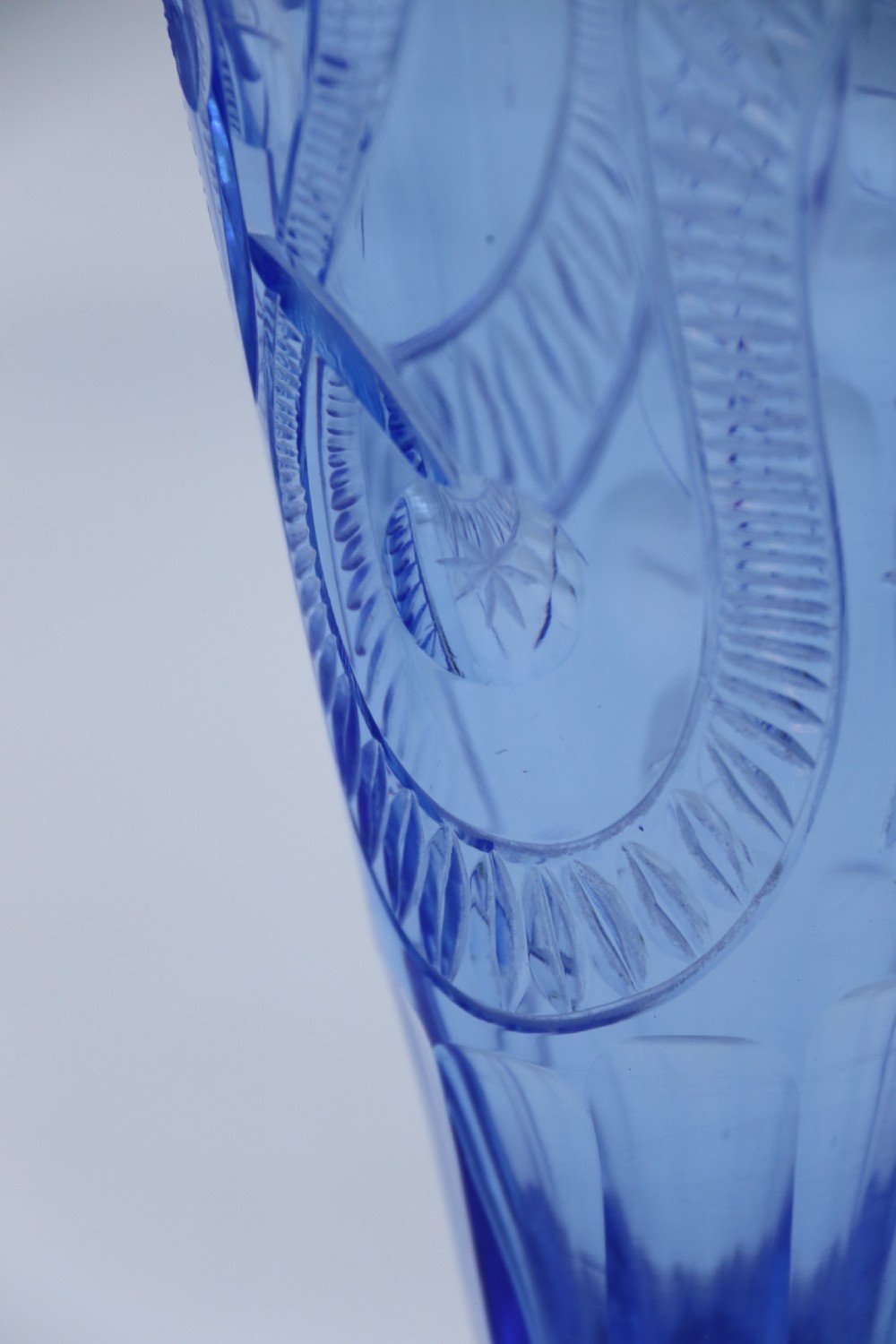 A flared Art Deco sapphire blue cut glass vase featuring geometric carved details on a faceted bulbous pedestal base. View IX