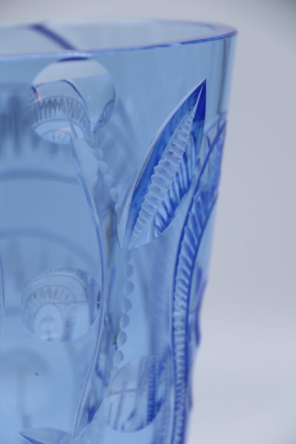 A flared Art Deco sapphire blue cut glass vase featuring geometric carved details on a faceted bulbous pedestal base. View XII